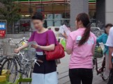 街頭配布の風景です。　弊社イメージカラーのピンクのユニフォームを着用。